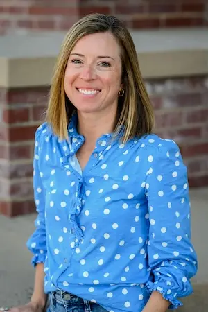 A headshot of Kelly Sevier, Commercial Project Manager at Legacy Construction Group in Cheyenne, Wyoming in front of Cheyenne Frontier Days Headquarters Building