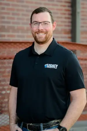 A headshot of Matt Silvester, Commercial Project Engineer at Legacy Construction Group in Cheyenne, Wyoming in front of Cheyenne Frontier Days Headquarters Building