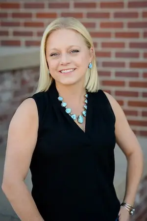 A headshot of Cailey Reiman-Garrett, Chief Operations Officer at Legacy Construction Group in Cheyenne, Wyoming in front of Cheyenne Frontier Days Headquarters Building